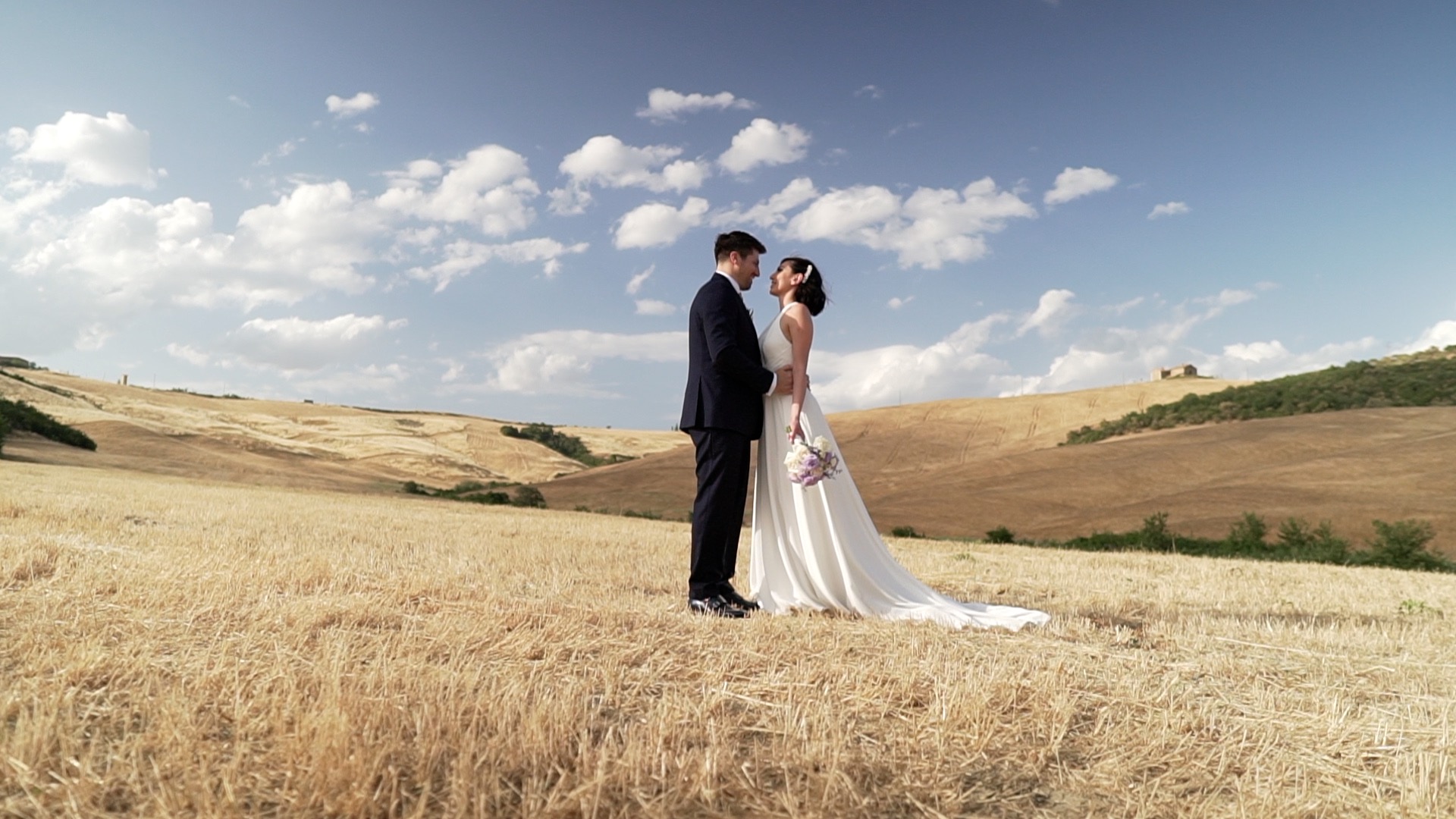 Serena-e-Edoardo-1 Image taken from a wedding video in Italy created by Tommaso Scalise, an expert videographer specializing in weddings in Italy. Here, the couple is sharing a kiss in the middle of a campo di grano (wheat field).